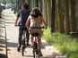  jeune femme en robe sur un vélib, roulant sur une piste cyclable